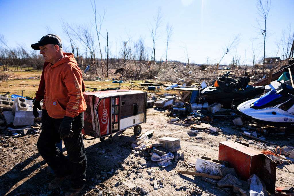 A man removes a Coke vending machine from the house of a man