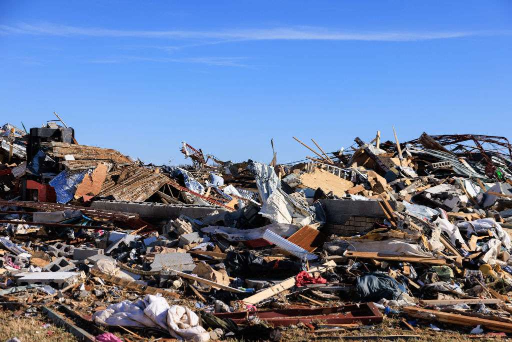 House and structure debris are piled after a tornado tore