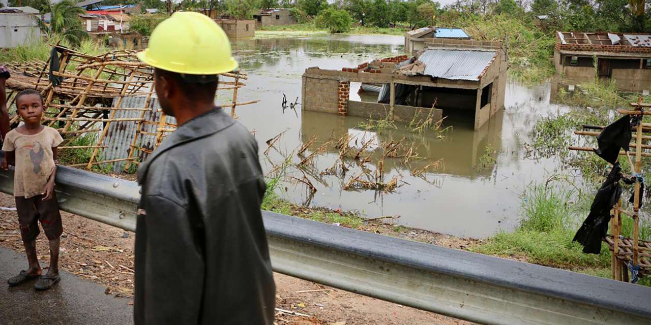 Local olha para uma casa destruída na aldeia de Tica
