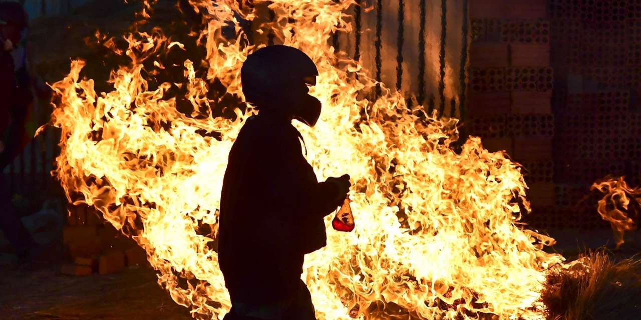 Um homem caminha em frente a uma barricada erguida por apoiantes do ex-Presidente da Bolívia Evo Morales em Cochabamba