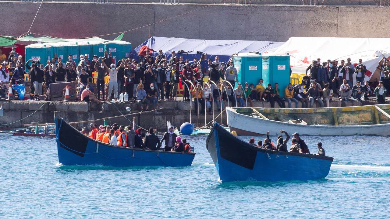 epa08825438 Two boats with migrants are welcomed by other migrants upon their arrival at Arguineguin port, Gran Canaria island, southwestern Spain, 17 November 2020. Spanish authorities rescued 206 migrants on 17 November and 346 migrants a day earlier off Canary Islands. In total, Spain has so far rescued some 17,000 migrants in 2020.  EPA/QUIQUE CURBELO