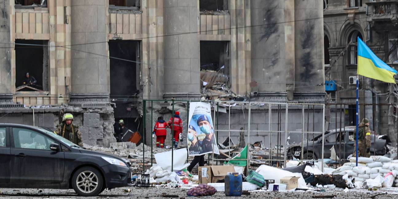 epa09793338 People examine a damaged administrative building in the aftermath of a Russian shelling in downtown Kharkiv, Ukraine, 01 March 2022. Russian troops entered Ukraine on 24 February prompting the country's president to declare martial law and triggering a series of announcements by Western countries to impose severe economic sanctions on Russia.  EPA/SERGEY KOZLOV