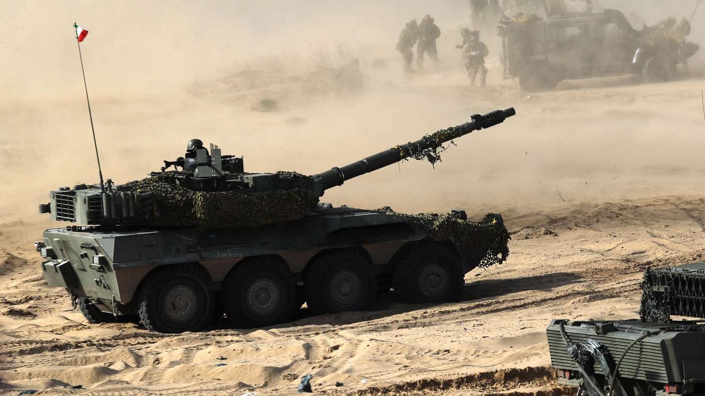 epa09817834 Spanish Army serviceman with their battle tank Leopard (R) during the international military exercise Crystal Arrow 22, organized by Mechanized Infantry Brigade of the Latvian Land Forces in Adazi training ground, Latvia, 11 March 2022. The purpose of the force demonstration is to demonstrate the interoperability of multinational units in various operations and to demonstrate NATO's combat capabilities for the protection of any member of the Alliance. With the conclusion of the Crystal Arrow 2022 exercise, the certification process of the NATO Extended Presence Battlegroup in Latvia is being successfully completed.  EPA/TOMS KALNINS