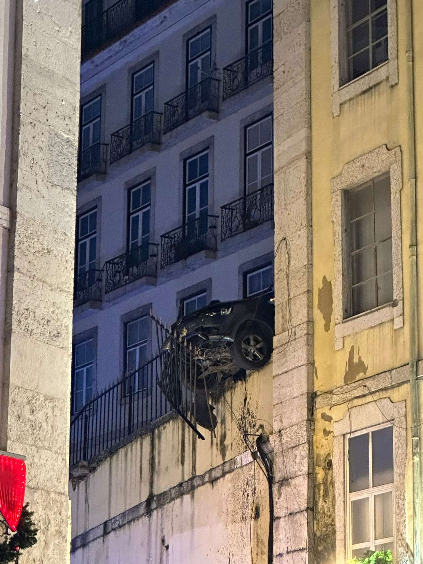 Carro pendurado na Calçada do Ferragial, em Lisboa, após colisão