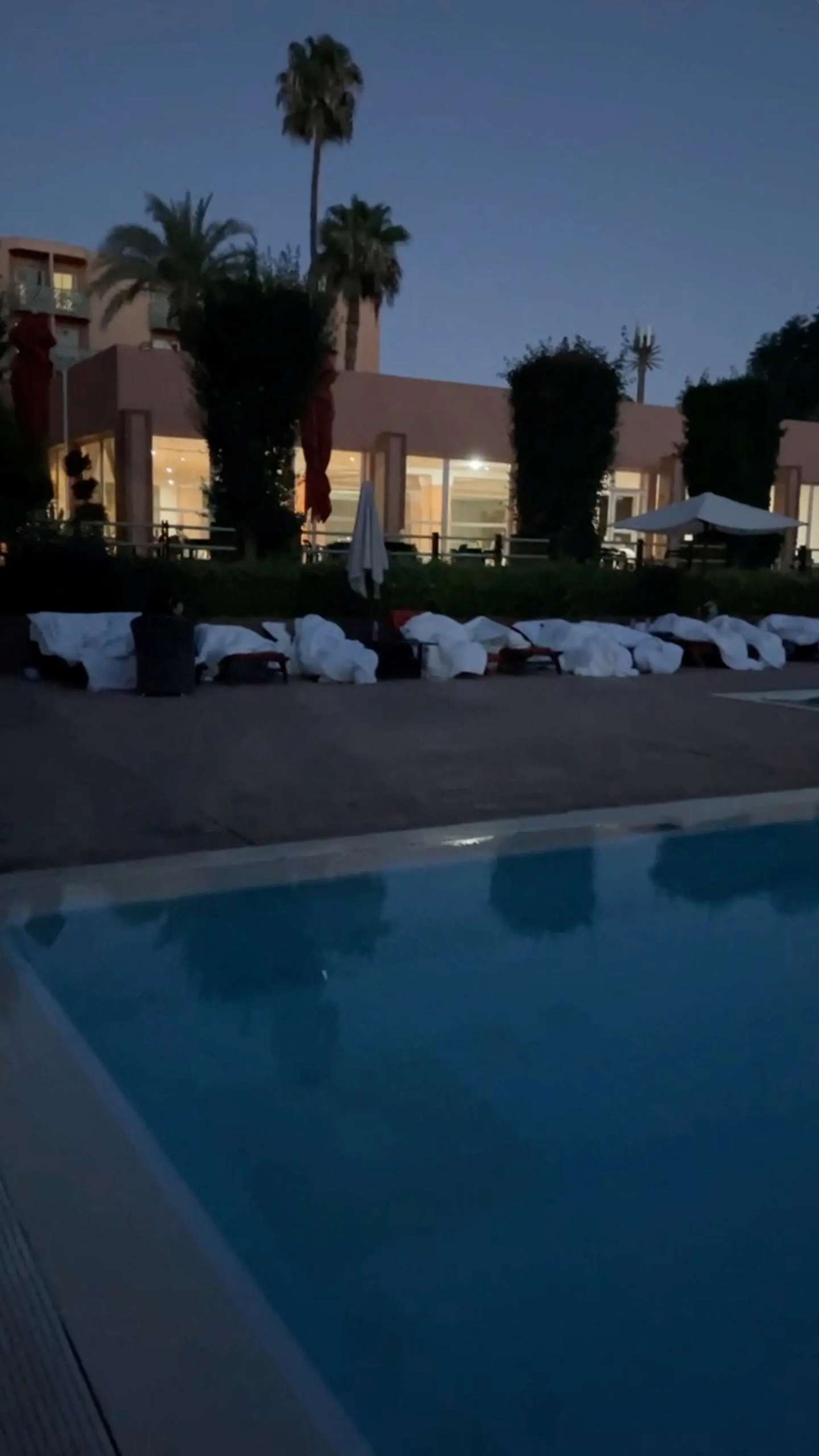 Turistas dormem à volta de piscina de hotel em Marraquexe