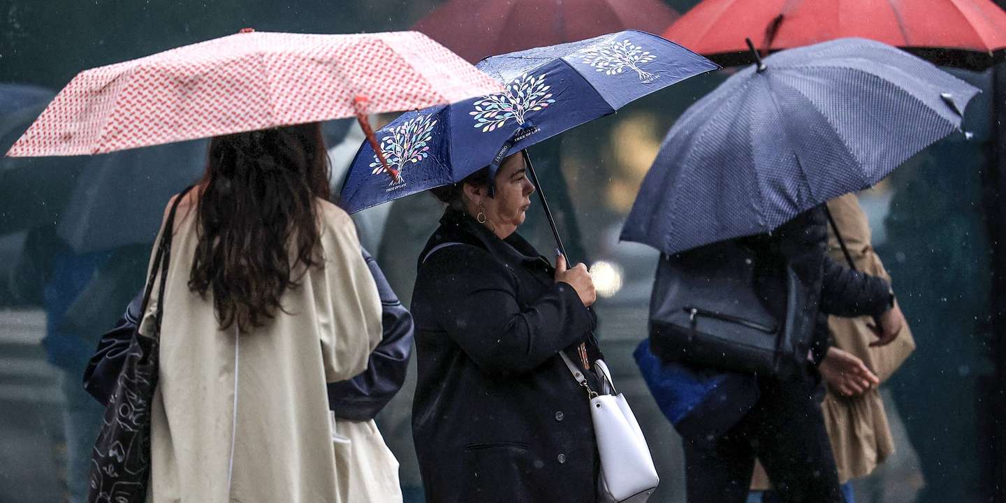 Jovens abrigam-se da chuva com um guarda-chuva junto ao Hospital São João, no Porto, 24 de setembro de 2024. De acordo com o Instituto Português do Mar e da Atmosfera (IPMA), prevê-se a ocorrência de períodos de chuva persistente a partir de hoje nas regiões Norte e Centro e que será por vezes forte na quarta e quinta-feira. ESTELA SILVA/LUSA