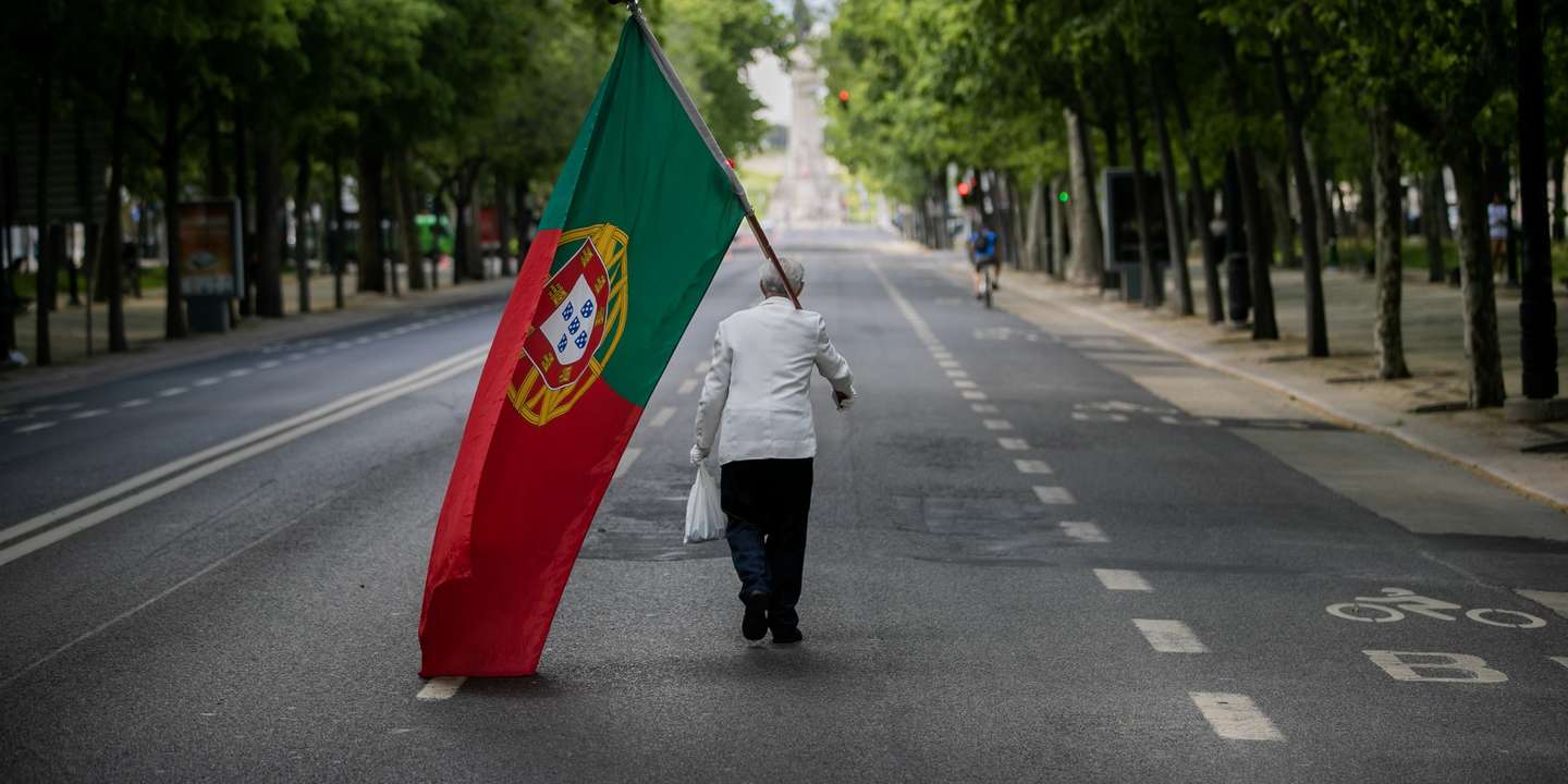 CONJUNTO DE 30 FOTOGRAFIAS SOBRE UM ANO DE ESTADO DE EMERGÊNCIA: 16-30: Foto datada de 25/04/2020: Um homem com uma bandeira de Portugal sobe a Avenida da Liberdade em Lisboa, por volta das 15 horas, altura em que anualmente se realiza um desfile comemorativo do 25 de abril de 1974 e que, devido à pandemia da covid-19, não pode ter lugar, em Lisboa, 25 de abril de 2020. Os 46 anos do 25 de Abril estão a ser hoje celebrados de forma diferente em Portugal, com uma sessão solene reduzida no parlamento, sem o tradicional desfile e com um apelo para que os portugueses cantem a ‘Grândola' à janela. JOSÉ SENA GOULÃO/LUSA