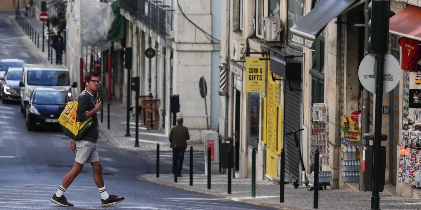 Um turista atravessa a rua da Madalena na zona da baixa pombalina de Lisboa, 20 de novembro de 2020. A falta de turismo na cidade de Lisboa devido à pandemia de Covid 19 levou a que muitos estabelecimentos comerciais, alguns deles emblemáticos e de familias há gerações estejam em risco de fechar. (ACOMPANHA TEXTO DA LUSA DE 22 DE NOVEMBRO DE 2020) TIAGO PETINGA/LUSA