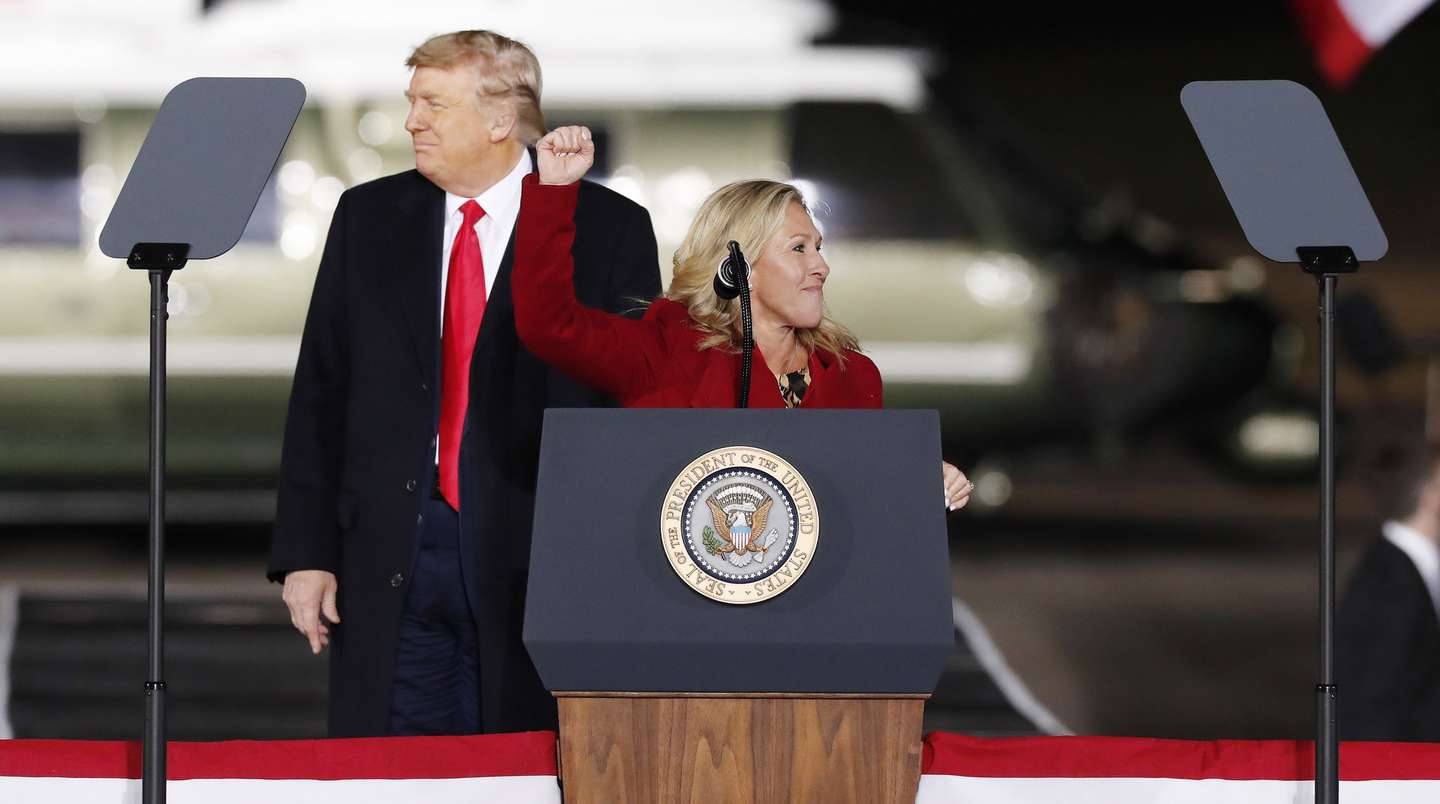 epa08919544 Republican US Representative from Georgia Marjorie Taylor Greene takes the podium in front of US President Donald J. Trump as he participates in an election eve campaign rally on behalf of Republican Georgia Senators Kelly Loeffler and David Perdue at Dalton Regional Airport in Dalton, Georgia, USA, 04 January 2021. Senator David Perdue is running Democrat Jon Ossoff and Republican Senator Kelly Loeffler is running against Reverend Raphael Warnock in the 05 January 2021 runoff election.  EPA/ERIK S. LESSER