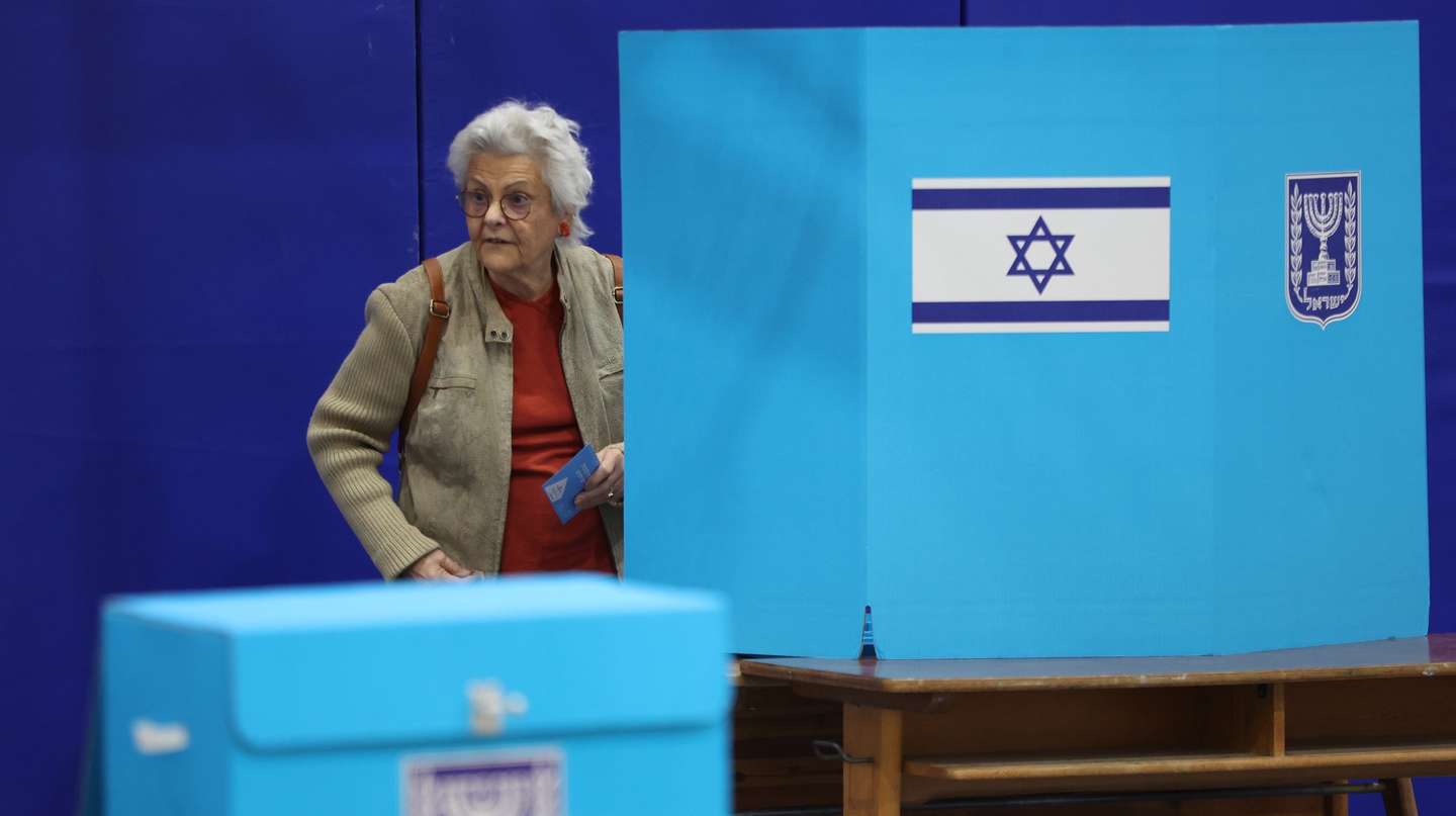 epa10278317 A woman at a voting booth before casting her vote at a polling station during Israeli general elections in Jerusalem, Israel, 01 November 2022. Israelis go to the polls during election day for the Israeli general elections, the fifth general election held in four years.  EPA/ABIR SULTAN