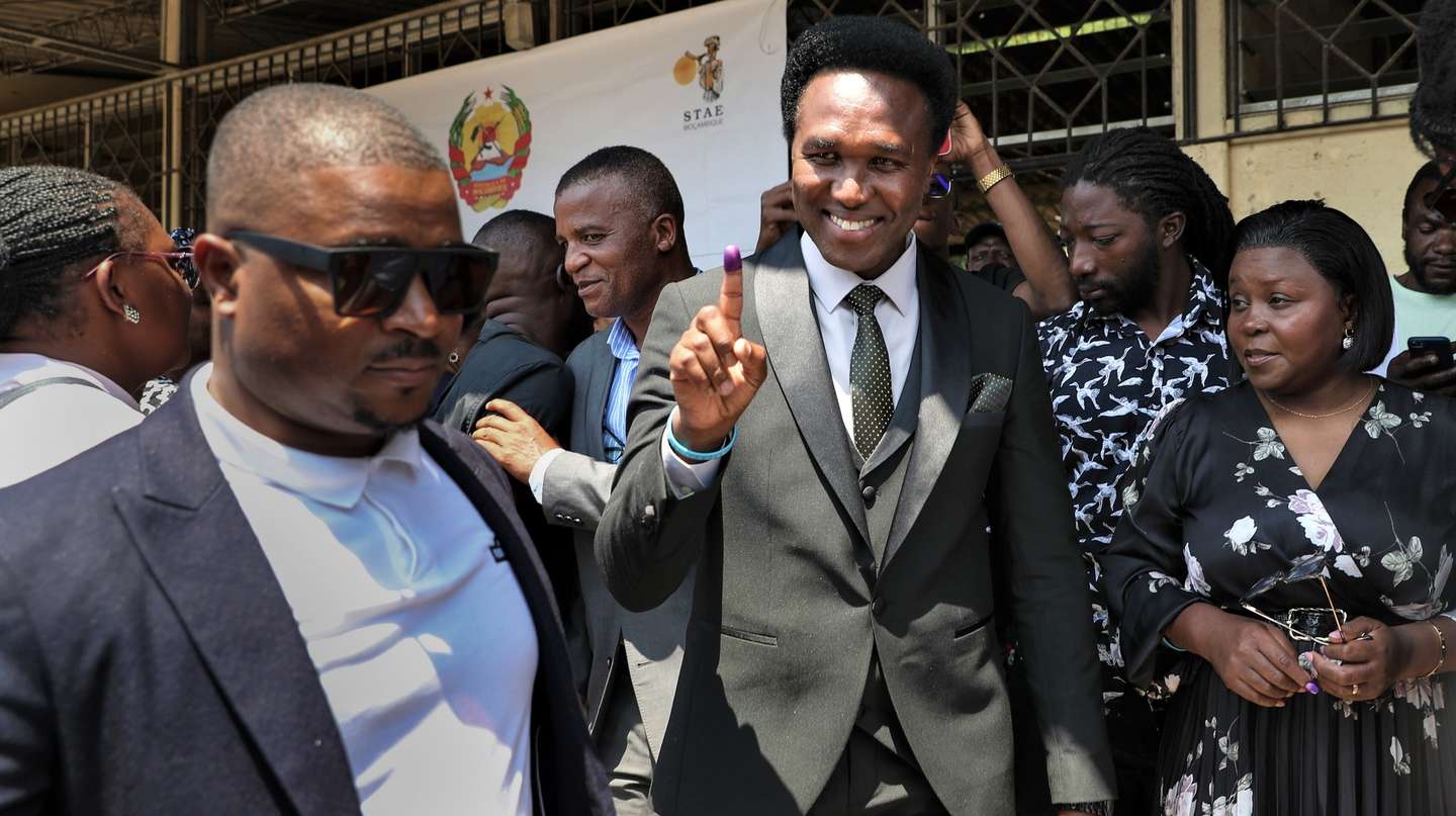 epa11650573 Presidential candidate Venancio Mondlane (C), supported by Podemos, shows his inked finger after casting his vote at a polling station in Maputo, Mozambique, 09 October 2024. More than 17.1 million Mozambican voters will choose the President of the Republic, provincial assemblies and their governors, and 250 members of the Assembly of the Republic. The National Elections Commission (CNE) approved lists of 35 political parties running for the Assembly of the Republic and 14 political parties and groups of citizen voters for provincial assemblies.  EPA/LUISA NHANTUMBO
