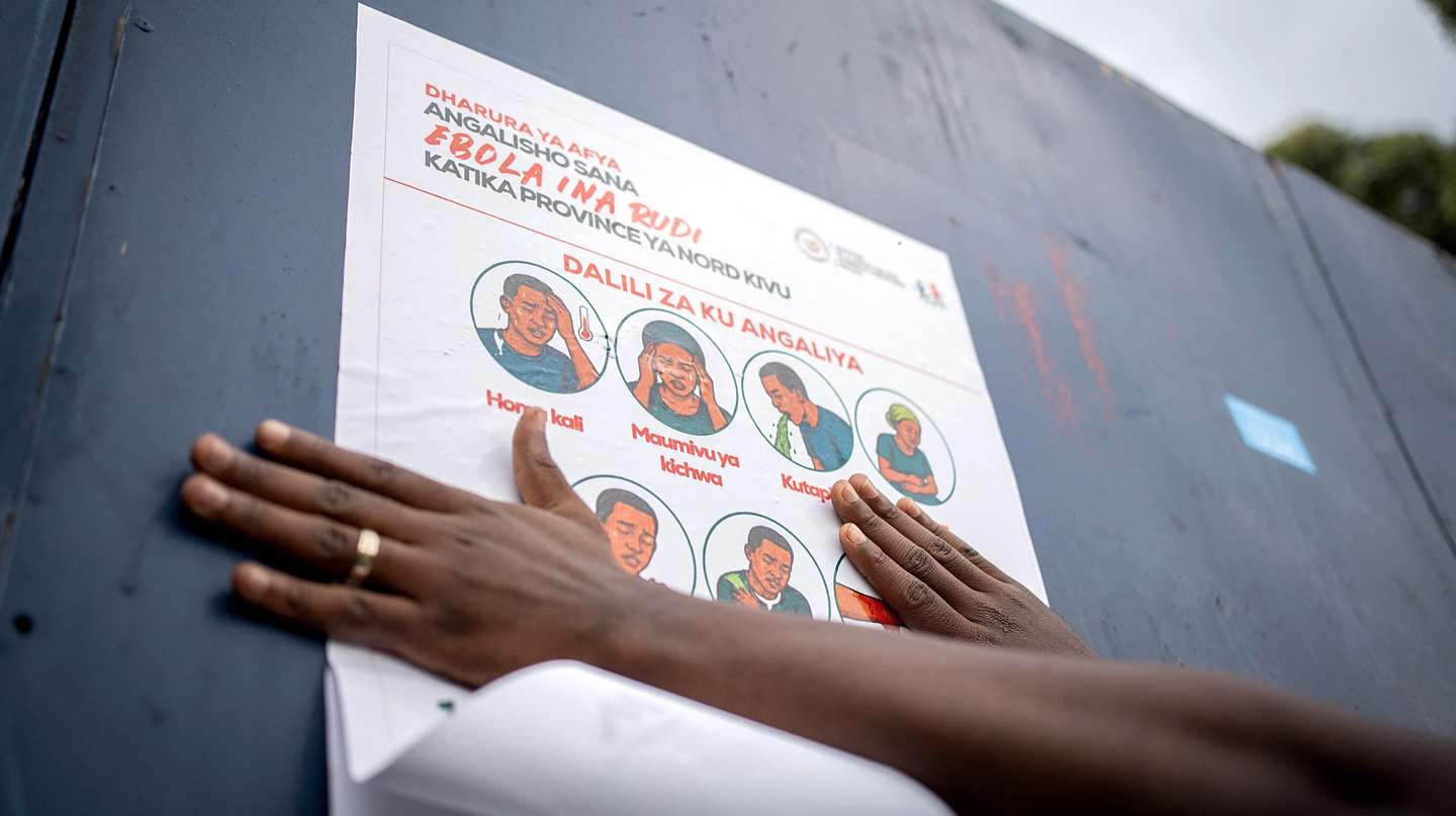epa12978406 A staff with the non-governmental organization AGIR-RDC that promotes medical access, displays a poster describing preventive measures against Ebola, in Goma, North Kivu, Democratic Republic of Congo, 20 May 2026. The World Health Organization (WHO) has reported over 130 deaths linked to the outbreak of the Bundibugyo variant of Ebola in the Democratic Republic of the Congo, officially declared public health emergency of international concern (PHEIC).  EPA/MARIE JEANNE MUNYERENKANA