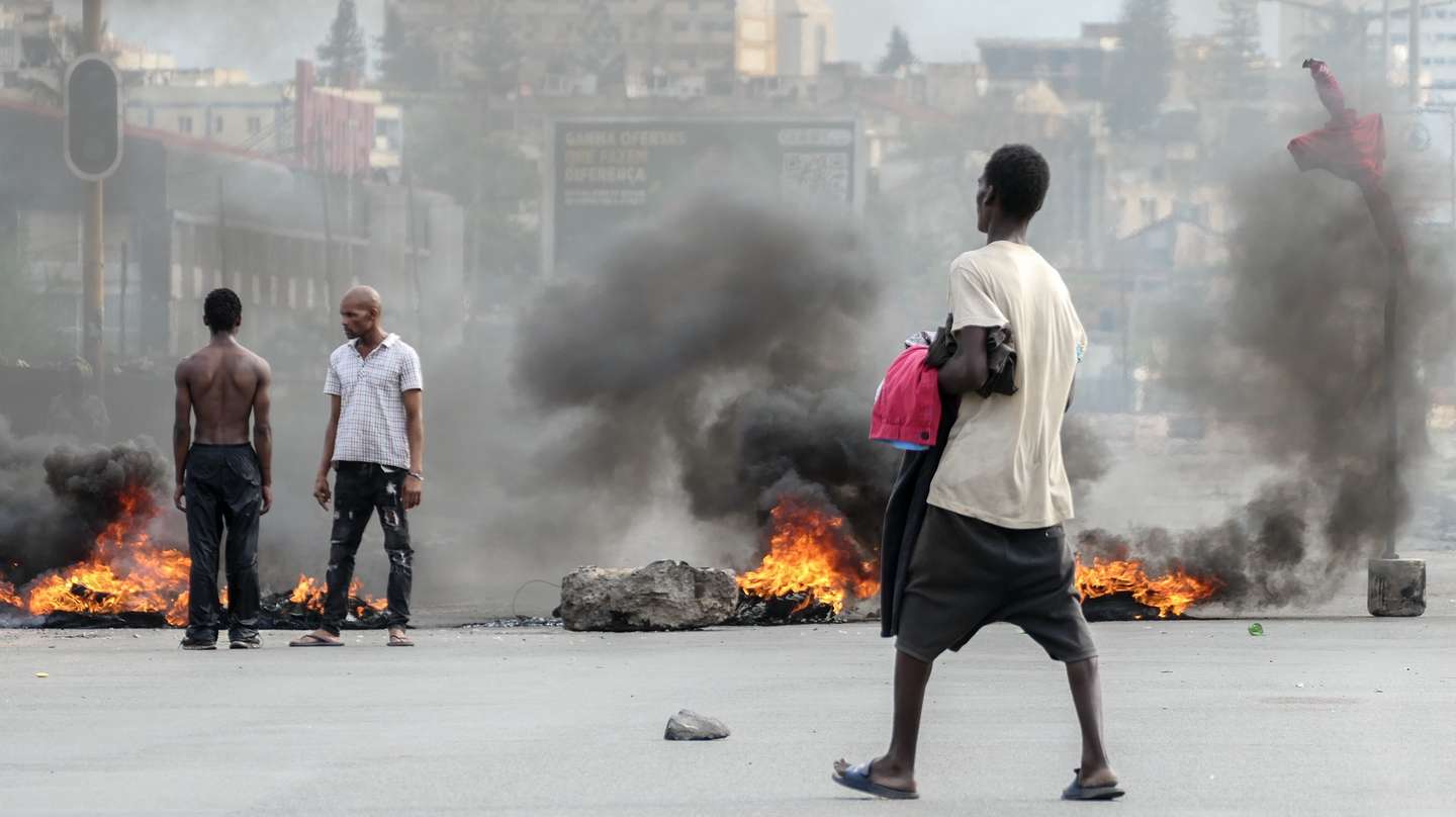 epa11791180 People stand next to a burning barricade during a protest after the Constitutional Council proclaimed Daniel Chapo as the winner of the presidential election with 65.17% of the votes, in Maputo, Mozambique, 23 December 2024. Daniel Chapo was proclaimed on 23 December as the fifth President of Mozambique following the elections held in October 2024.  EPA/PAULO JULIAO