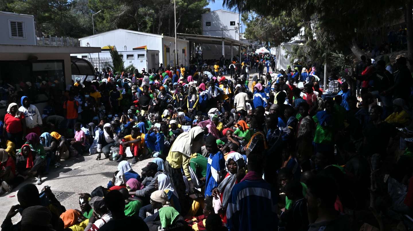 epa10863171 Migrants wait outside the hotspot to be transferred to the mainland on the Sicilian island of Lampedusa, southern Italy, 15 September 2023. A record number of migrants and refugees arrived on the southern Italian island of Lampedusa in recent days. Lampedusa's city council declared a state of emergency on 13 September evening, after a 48-hour continuous influx of migrants. In the morning of 14 September, nearly 7,000 migrants were on the island.  EPA/CIRO FUSCO