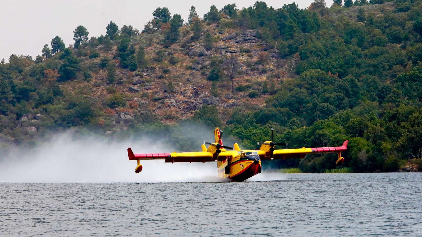 Um avião Canadair CL-415 enviado por Marrocos de combate aos incêndios faz o abastecimento de água durante o incêndio de grandes proporções que lavra há quatro dias no concelho de Trancoso, em Mendo Gordo, 12 de agosto de 2025. O incêndio, que deflagrou no sábado, está dividido em quatro frentes, duas das quais já estão dominadas e em rescaldo, havendo outras duas que causam preocupação. MIGUEL PEREIRA DA SILVA/LUSA
