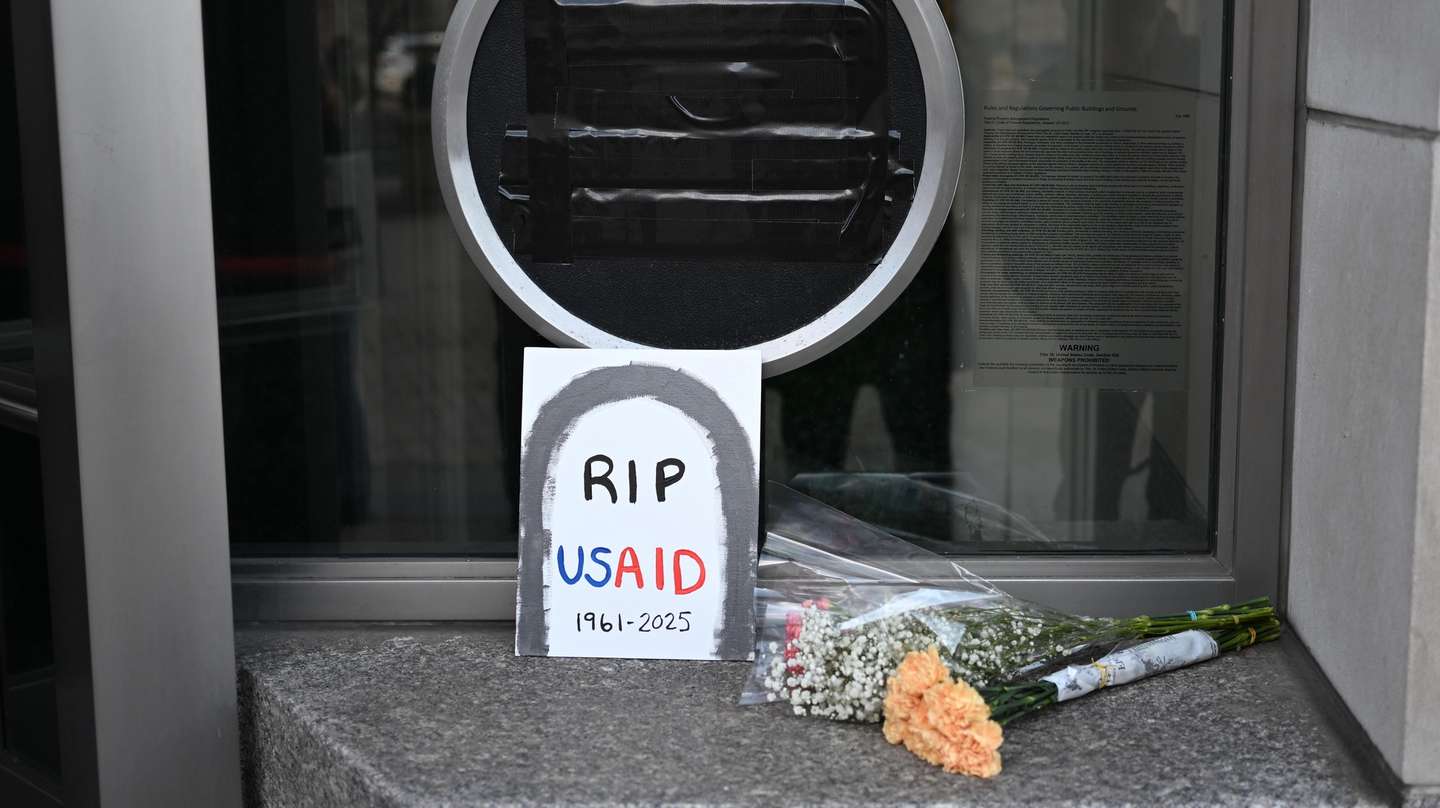 epa11881539 A sign and flowers lay near the entrance of the US Agency for International Development (USAID) headquarters in Washington, DC, USA, 07 February 2025. Following the Trump administration reorganization plans, spearheaded by billionaire Elon Musk, around 300 members were expected to remain out of the USAID's worldwide total of more than 10,000.  EPA/ALEX WROBLEWSKI