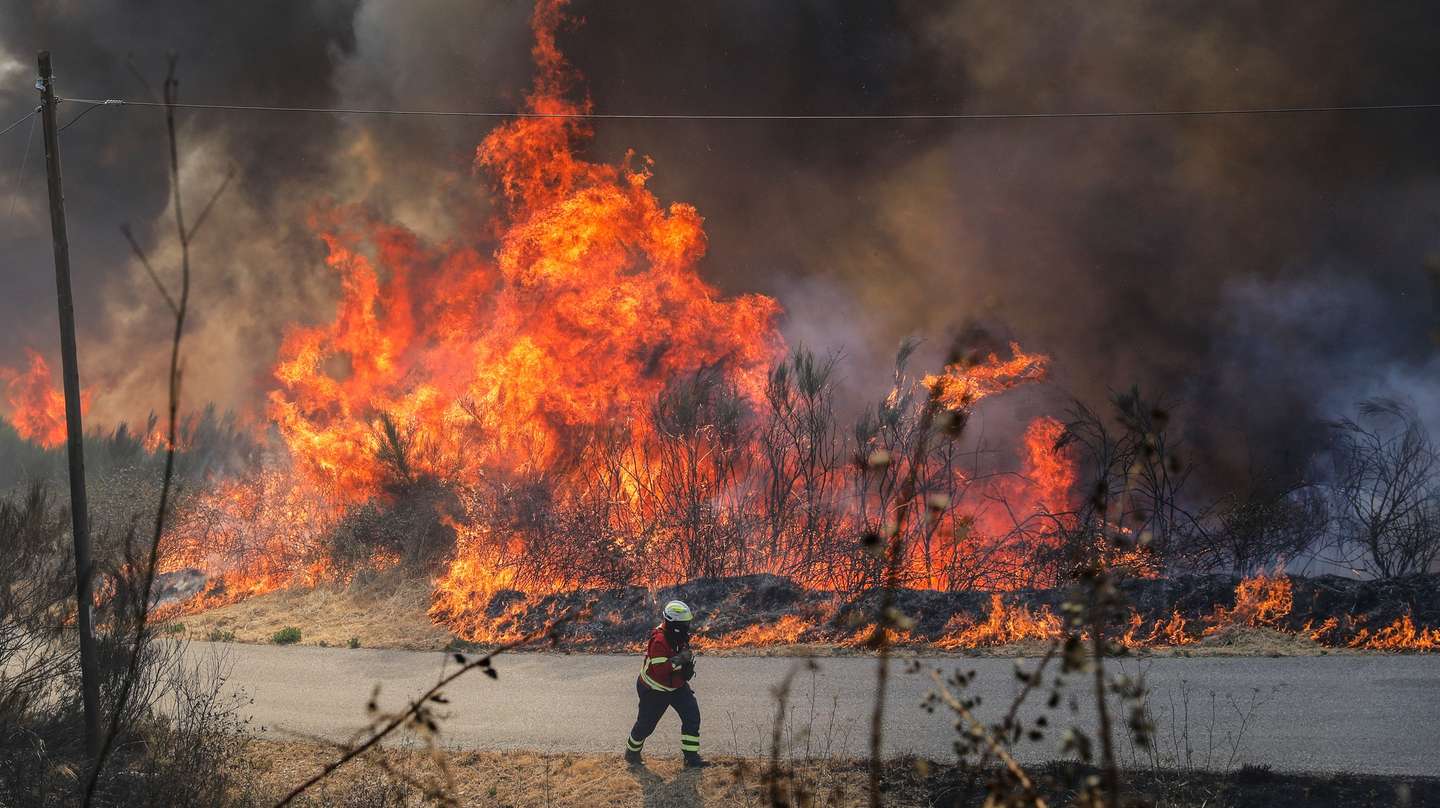 Um bombeiro combate as chamas durante o incêndio na encosta da aldeia de Moura da Serra, Arganil, 14 de agosto de 2025. De acordo com os dados disponíveis no ‘site’ da Autoridade Nacional de Emergência e Proteção Civil (ANEPC), quase 900 operacionais combatiam o fogo que deflagrou na quarta-feira na freguesia de Piódão, no concelho de Arganil, distrito de Coimbra, e se estendeu depois aos municípios de Oliveira do Hospital e Pampilhosa da Serra (Coimbra), e de Seia, já no distrito da Guarda. PAULO CUNHA/LUSA