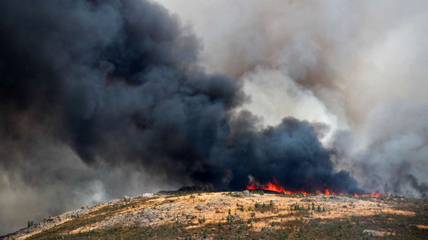 Uma coluna de fumo negro no ar durante o incêndio na encosta da aldeia de Moura da Serra, Arganil, 14 agosto 2025 em Arganil. De acordo com os dados disponíveis no ‘site’ da Autoridade Nacional de Emergência e Proteção Civil (ANEPC), quase 900 operacionais combatiam o fogo que deflagrou na quarta-feira na freguesia de Piódão, no concelho de Arganil, distrito de Coimbra, e se estendeu depois aos municípios de Oliveira do Hospital e Pampilhosa da Serra (Coimbra), e de Seia, já no distrito da Guarda. PAULO CUNHA/LUSA
