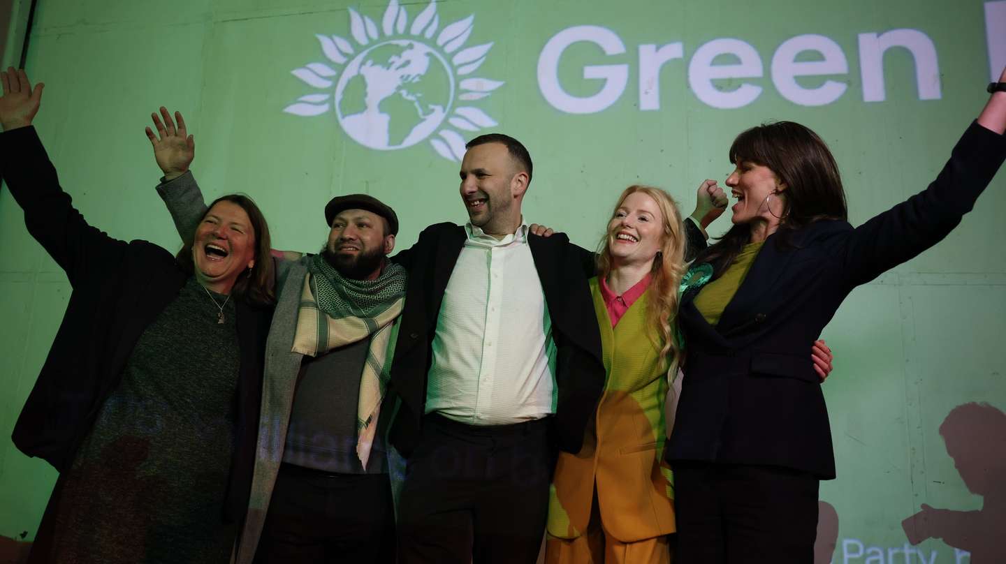 epa12780576 Green Party Leader Zack Polanski (C) attends and election after-event with Green Party winning candidate Hannah Spencer (2-R) after the vote count for the Gorton and Denton by-election in Manchester, Britain, 27 February 2026. Voters went to the polls on 26 February to elect a new Member of Parliament for the Gorton and Denton constituency, in a by-election triggered by the resignation of sitting MP Andrew Gwynne.  EPA/ADAM VAUGHAN
