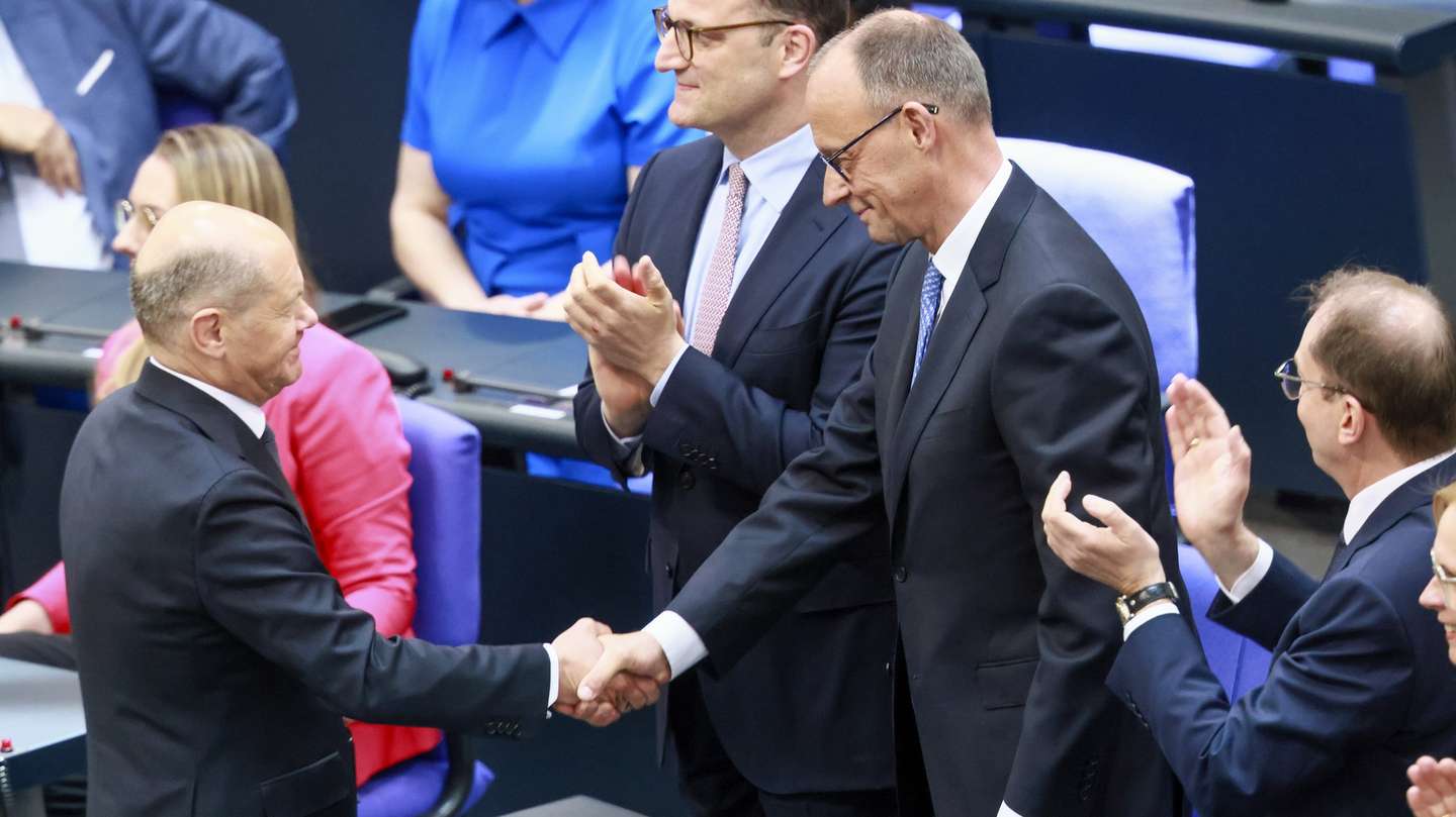 epaselect epa12077885 Outgoing German Chancellor Olaf Scholz (L) congratulates newly elected Chancellor Friedrich Merz (C) after the second round of voting at the Bundestag in Berlin, Germany, 06 May 2025. The new German government is expected to be formed between the Union parties of Christian Democratic Union (CDU) and Christian Social Union (CSU) and the coalition partner Social Democratic Party (SPD).  EPA/HANNIBAL HANSCHKE