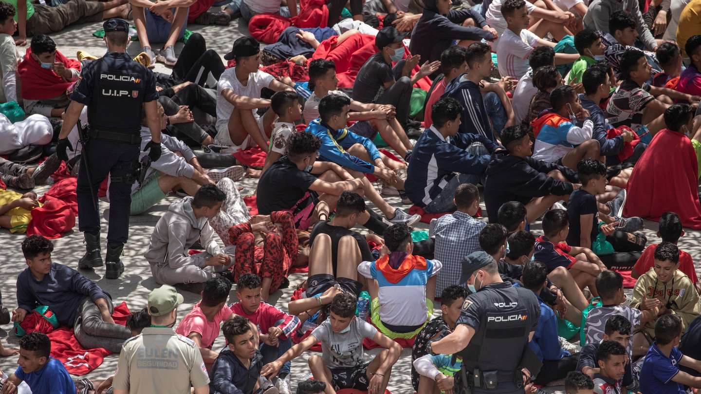 epa09218156 Migrants wait at an industrial estate next to Tarajal beach, in the city of Ceuta, Spanish enclave in northern Africa, 21 May 2021. Local authorities reported that between 8,000-10,000 migrants managed to enter Spain from 18 to 19 May.  EPA/BRAIS LORENZO ATTENTION EDITORS: FACES PIXELATED AT SOURCE DUE TO LEGAL REQUIREMENTS