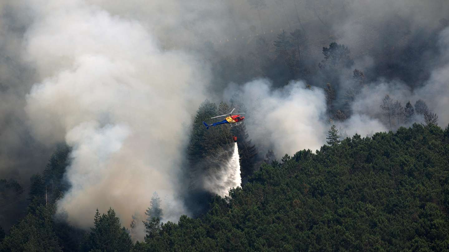 Um helicóptero combate o incêndio que se desenvolve em área de montanha no Parque Natural do Alvão próximo da aldeia de Pardelhas, em Mondim de Basto, 04 de Agosto de 2025. ESTELA SILVA/LUSA