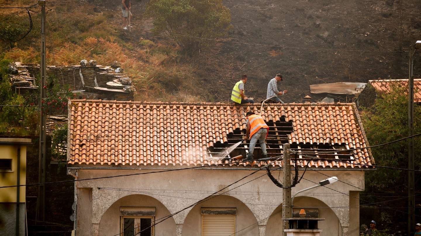 Populares apagam um incêndio numa casa na aldeia de Mourisia, Arganil, 14 de agosto de 2025. De acordo com os dados disponíveis no ‘site’ da Autoridade Nacional de Emergência e Proteção Civil (ANEPC), quase 900 operacionais combatiam o fogo que deflagrou na quarta-feira na freguesia de Piódão, no concelho de Arganil, distrito de Coimbra, e se estendeu depois aos municípios de Oliveira do Hospital e Pampilhosa da Serra (Coimbra), e de Seia, já no distrito da Guarda. PAULO CUNHA/LUSA