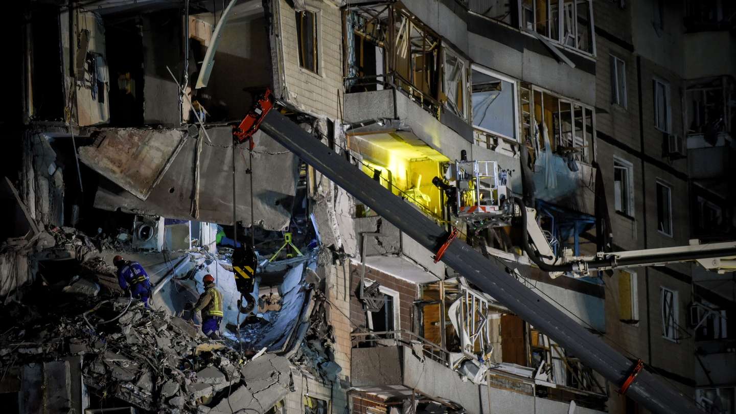 epa10407421 Rescue workers remove debris at the site of a damaged residential building in Dnipro, southeastern Ukraine, 15 January 2023, amid Russia's invasion. At least 25 people died, including one child, 73 other were injured, including 13 children, and 43 reports of missing persons were received, after a rocket hit a nine-story building in Dnipro on 14 January, the State Emergency Service (SES) of Ukraine said in a statement. Russian troops entered Ukraine on 24 February 2022 starting a conflict that has provoked destruction and a humanitarian crisis.  EPA/OLEG PETRASYUK