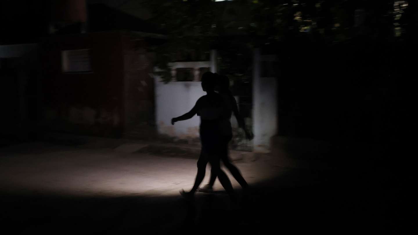 epa11967480 People walk down a street in the dark due to no electricity in Havana, Cuba, 15 March 2025. Work to re-establish the National Electric System (SEN) in Cuba after the total blackout that began on 14 March progressed slowly and laboriously, while most of the island's population remains without power 24 hours after the collapse.  EPA/ERNESTO MASTRASCUSA
