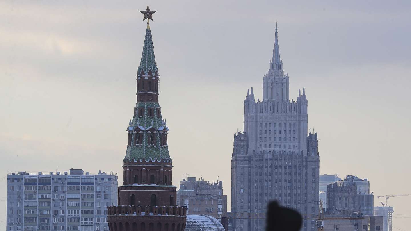 epa10308333 A woman walks in front of Moscow Kremlin and the Russian Foreign Ministry building after a snowfall in downtown Moscow, Russia, 16 November 2022. Meteorological winter has come to Moscow. On 15 November, heavy snowfall began in the capital, which did not stop at night. Utilities are clearing roads and sidewalks, and weather forecasters say the snow cover will not melt until spring.  EPA/MAXIM SHIPENKOV