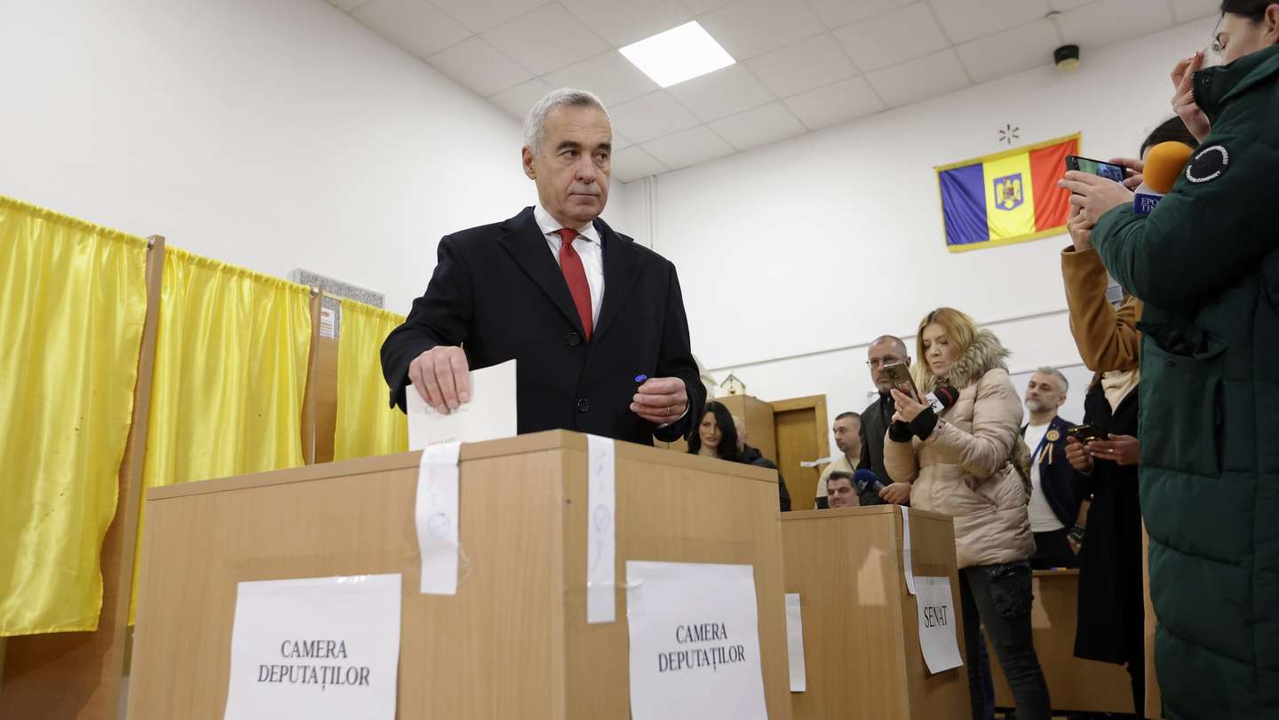 epa11750813 Romanian far-right independent runoff candidate Calin Georgescu (L) casts his ballot for the parliamentary elections at a polling station in Secondary School No. 1 in Mogosoaia village, near Bucharest, Romania, 01 December 2024. Approximately 18 million Romanian citizens are expected at the polling stations this weekend for choosing the bicameral parliament members, according to the Permanent Electoral Authority (AEP), of which 989,230 people can express their intention abroad. Calin Georgescu led in the first round of the presidential race, winning 22.94 percent of the total number of votes, followed by Elena Lasconi, leader of the USR (Save Romania Union), with 19.18 percent. The second round of Romania's presidential election will be held on 08 December 2024.  EPA/ROBERT GHEMENT