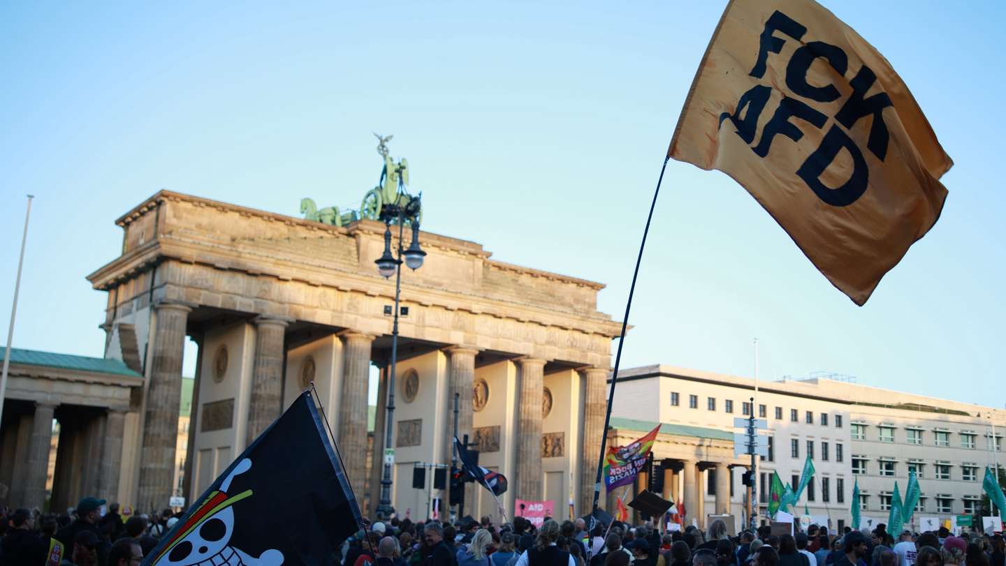 epa13220463 A participant waves a flag that reads 'FCK AFD' during a rally at the Brandenburg Gate in Berlin, Germany, 07 September 2026. The protest was scheduled a day after the far-right Alternative for Germany party (AfD) won the election in the regional state of Saxony Anhalt by a wide margin.  EPA/CLEMENS BILAN