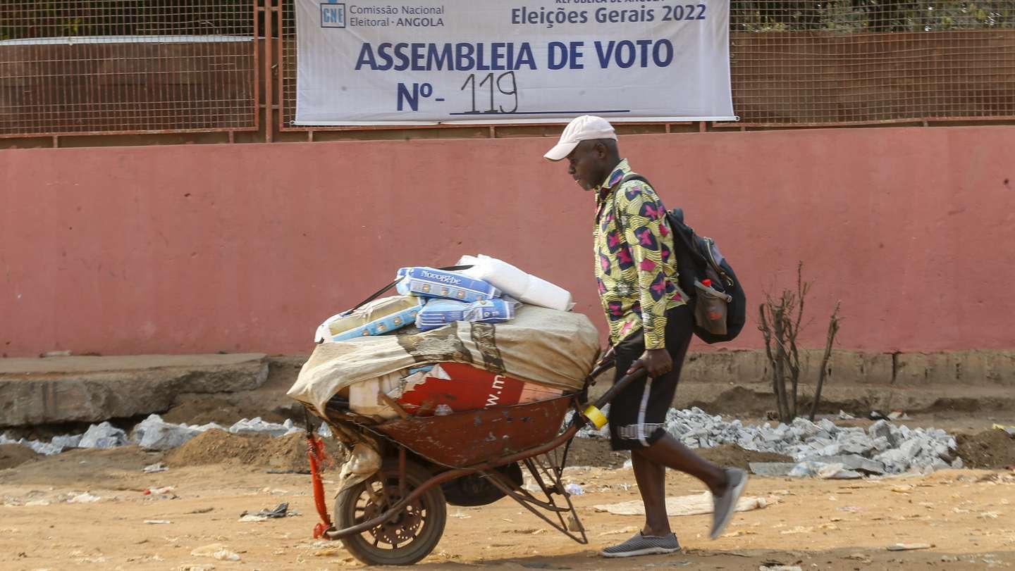 Um popular passa junto de um cartaz da Comissão Nacional de Eleições de Angola, Luanda, Angola, 10 de agosto de 2022. As eleições gerais angolanas, quinto escrutínio da história política do país, estão marcadas para 24 de agosto e contam com candidaturas de oito formações políticas, que estão em campanha eleitoral desde 24 de julho. (ACOMPANHA TEXTO DE 13-08-2022)  AMPE ROGÉRIO/LUSA