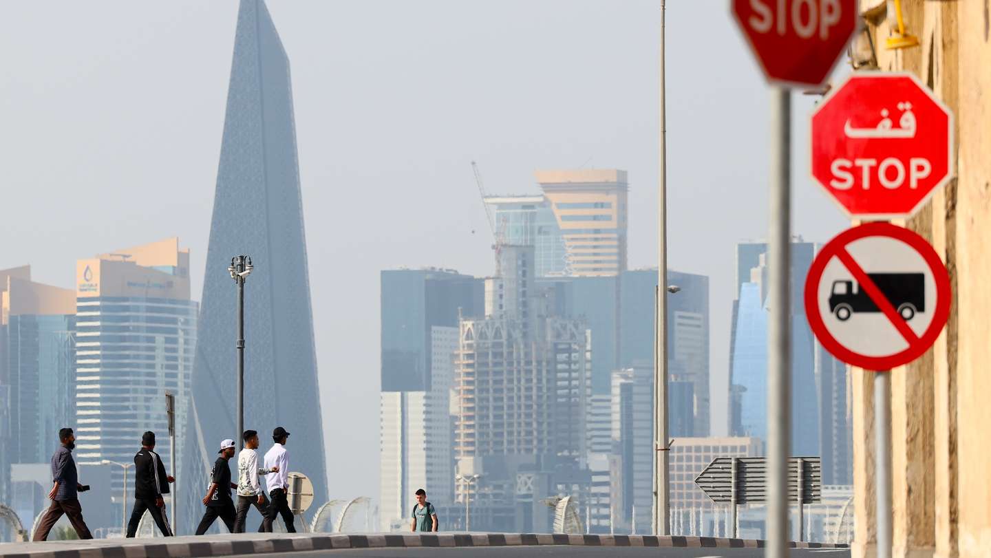epa12787204 People walk through the old town city center in front of the skyline in Doha, Qatar, 01 March 2026. Iran continues to retaliate with attacks against Israel and the Gulf countries after joint US and Israeli military attacks on Iran on 28 February 2028.  EPA/HANNIBAL HANSCHKE