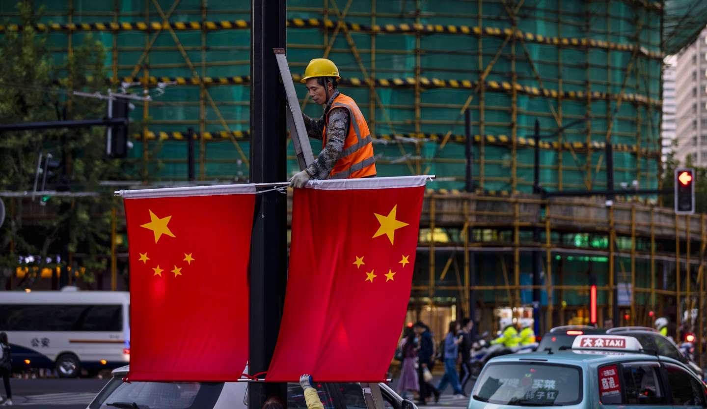 epa08729010 A man removes Chinese flags from the pole after National Holiday in Shanghai, China, 08 October 2020. At the government organised press conference in Beijing on 29 September, state economists praised Chinese President Xi Jinping over domestic dual-circulation strategies a 'high-quality' development and 'high-quality' growth. This new economic plan comes after COVID-19 unfavourable economic impact and weak purchasing power of domestic population.  EPA/ALEX PLAVEVSKI