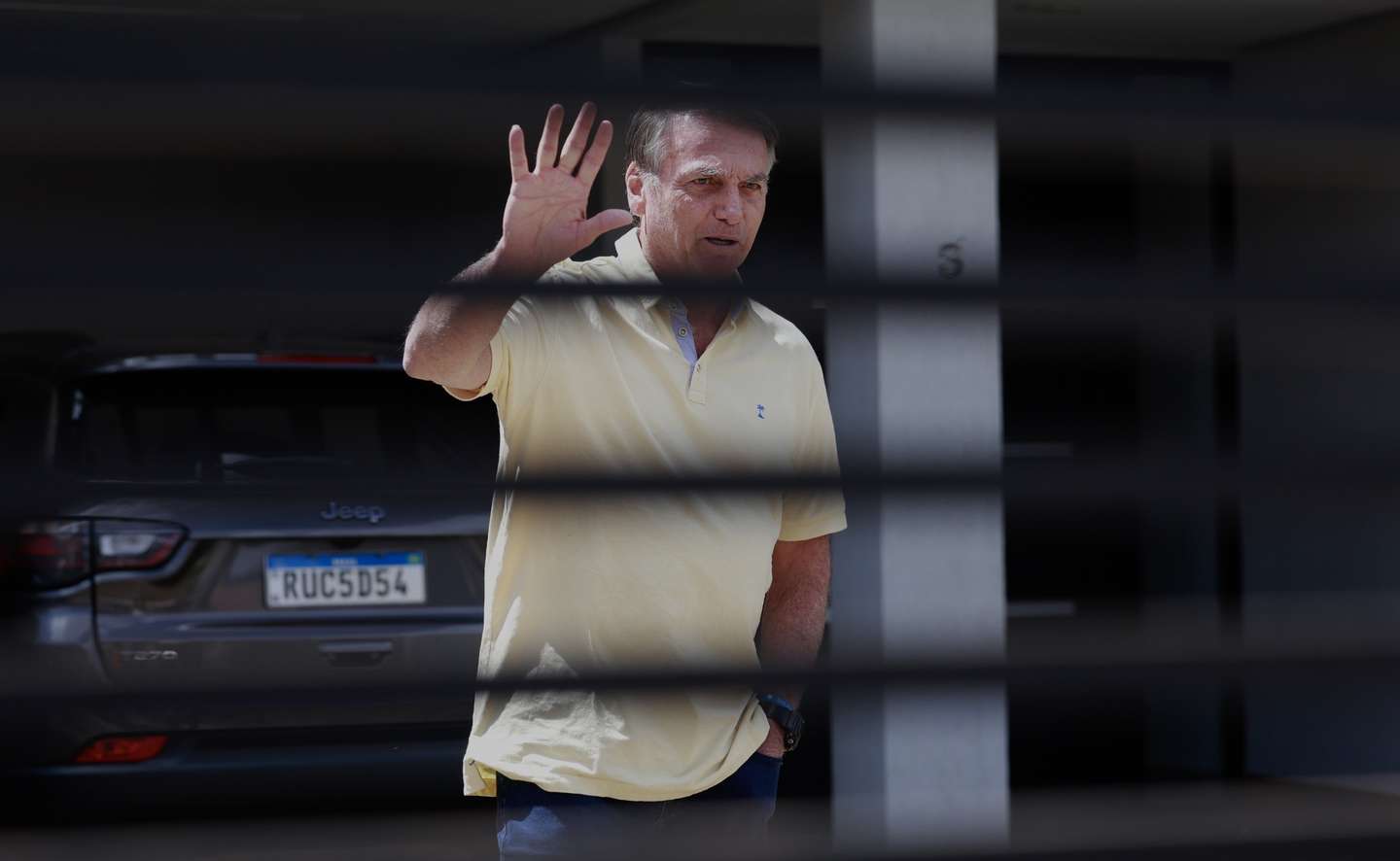 epa12349698 Brazil's former president Jair Bolsonaro waves from inside his residence in Brasilia, Brazil, 03 September 2025. Bolsonaro's defense team denied before the Supreme Court that the former Brazilian president participated in a coup plot and reduced the prosecution's accusation to 'suppositions' in a session that has left the trial ready for sentencing.  EPA/SEBASTIAO MOREIRA