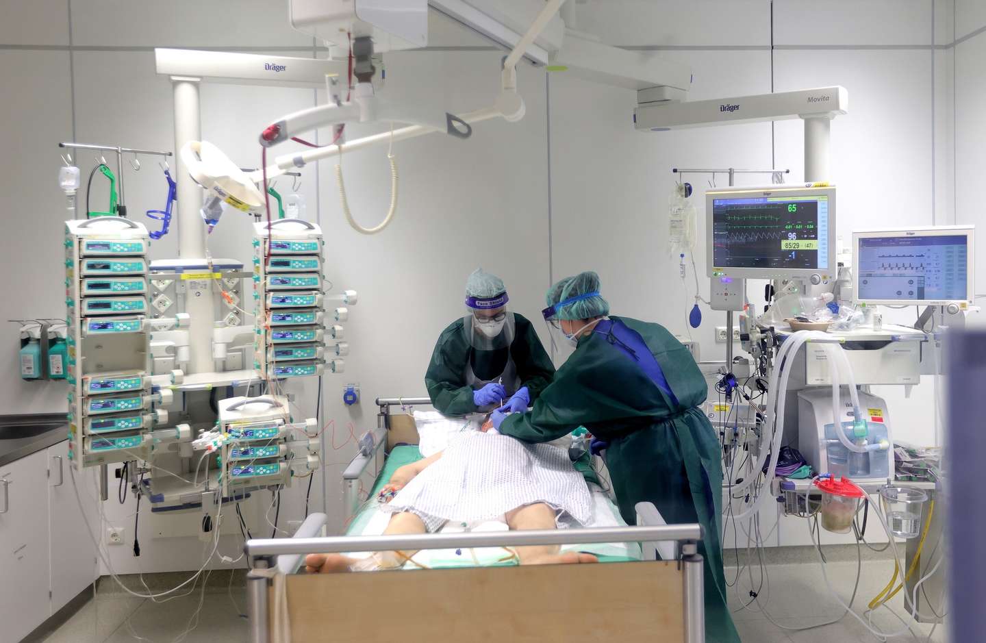 epa08761952 Medical staff takes care of a Corona patient at the intensive care unit of the University Hospital in Essen, Germany, 21 October 2020. The University Hospital Essen treats several patients in its intensive care unit who are seriously ill with the corona virus. Countries around the world are stepping up measures to stem the reappearance in a second wave of the SARS CoV-2 coronavirus, which causes COVID 19 disease.  EPA/FRIEDEMANN VOGEL