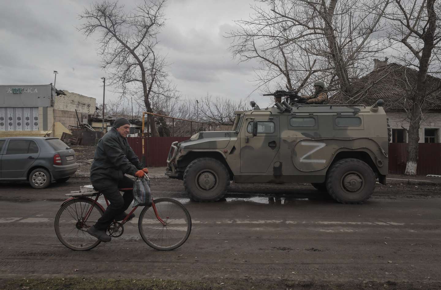 epa09853298 Local man with humanitarian aid bicycling in front of Russian army all-terrain infantry mobility vehicle ‘Tigr’ during food distribution organised by Russian army and militias of self-proclaimed LPR in village Trokhizbenka, Luhansk region, Ukraine, 27 March 2022. Chairman of the Government of the LPR Sergey Kozlov reported that as of March 22, the retreating Kyiv (Kiev) security forces had blown up 22 bridges, but the Republic would restore them. Russia will assist in the restoration and construction of infrastructure in the Republic. On 24 February Russian troops had entered Ukrainian territory in what the Russian president declared a 'special military operation', resulting in fighting and destruction in the country, a huge flow of refugees, and multiple sanctions against Russia. The letter Z has been used by Russian forces as an identifying sign on their vehicles in Ukraine.  EPA/SERGEI ILNITSKY