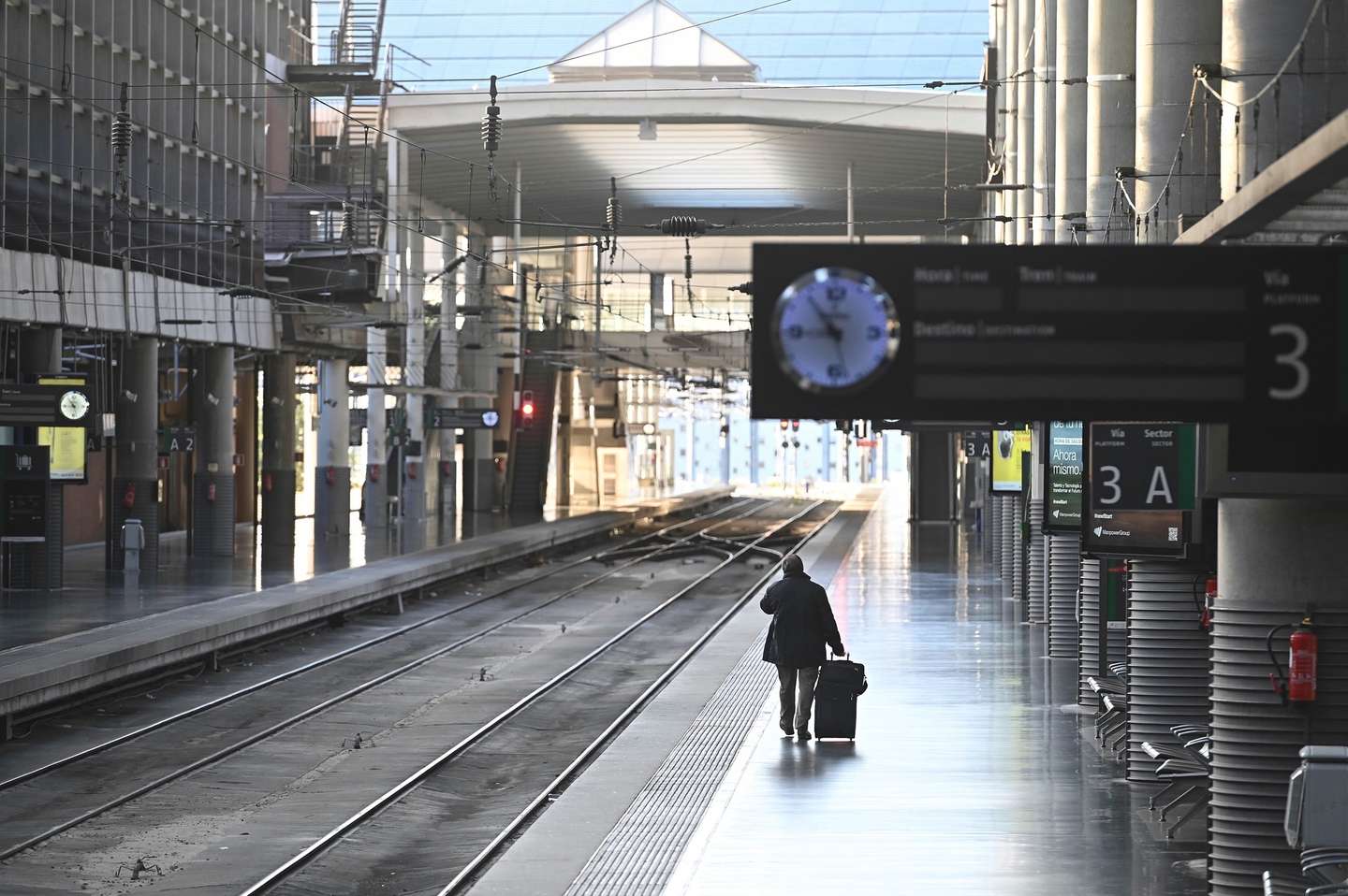 epa08721532 A man walks with his luggage as he waits for a high speed train at Atocha train station in Madrid, Spain, 05 October 2020. Madrid capital city and other nine towns in the region have been 'closed' by the central government to avoid mobility between those cities with high number of coronavirus cases amid a dispute between the central and regional governments on how to lower the epidemiological curve in the region. Madrid's regional government filed a complaint at the Audiencia Nacional Court to avoid the closure of cities but restrictions have been carried out while the court rules out a decision on the matter.  EPA/Fernando Villar