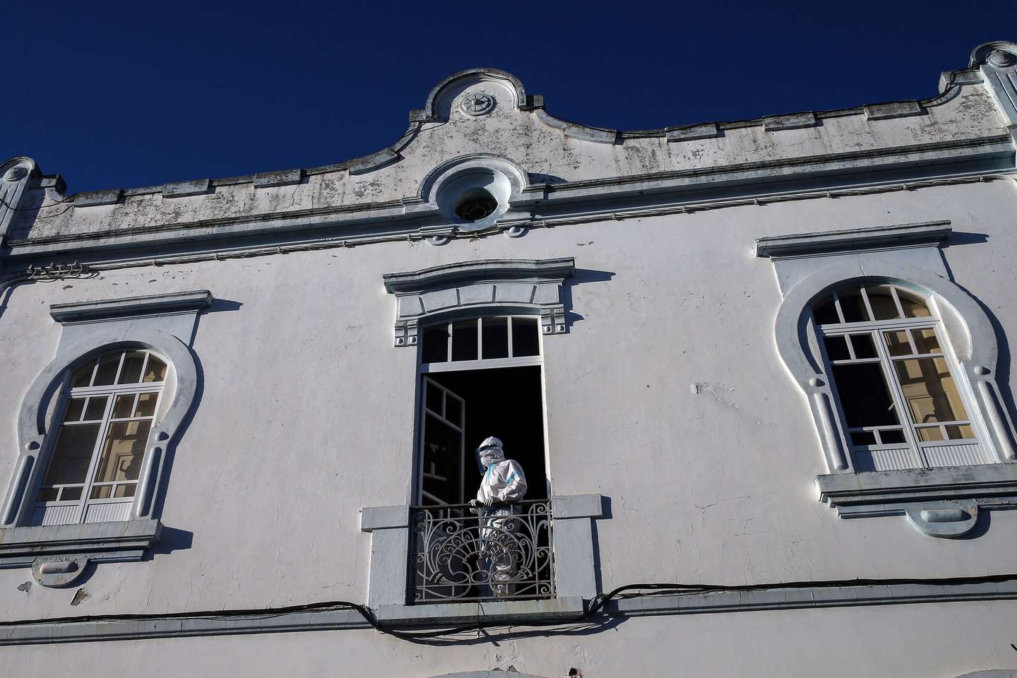 Um técnico na janela do lar enquanto são transportados em ambulâncias os idosos infetados com covid-19 que estão a ser transferidos do lar de Reguengos de Monsaraz para um pavilhão preparado para o efeito, Reguengos de Monsaraz, 03 de julho de 2020. O lar da Fundação Maria Inácia Vogado Perdigão Silva (FMIVPS), foi onde surgiu um surto da doença, no dia 18 de junho. NUNO VEIGA/LUSA