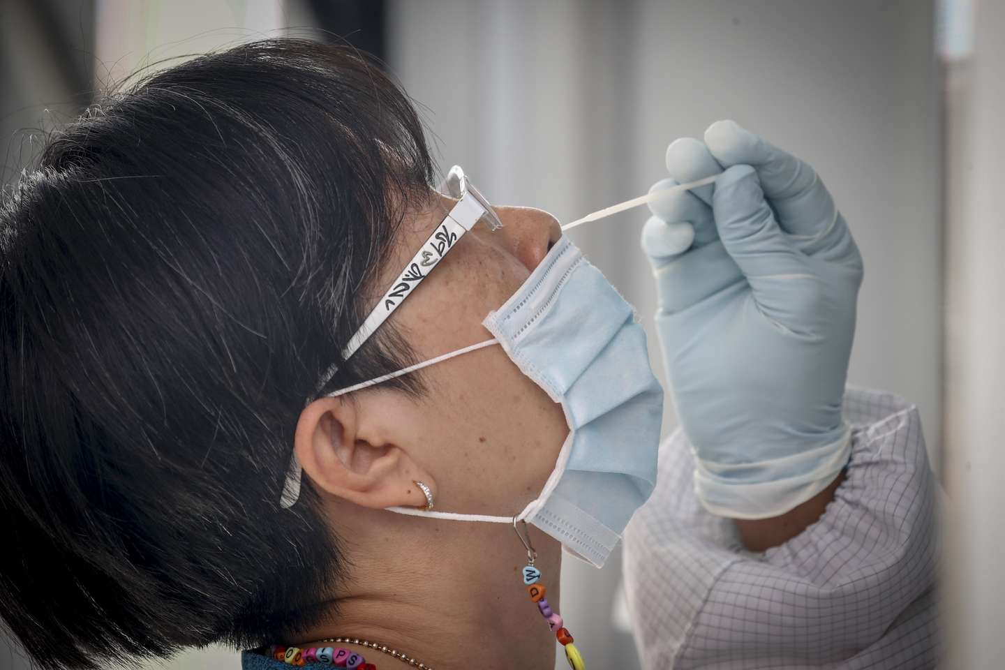 epa09134291 A woman undergoes a nasal swab test to detect COVID-19 amid a spike in infections, at the backpackers' hotspot of Khaosan road in Bangkok, Thailand, 14 April 2021. Authorities are stepping up both testing and vaccinations in high risk areas following the recent spike in COVID-19 cases.  EPA/DIEGO AZUBEL