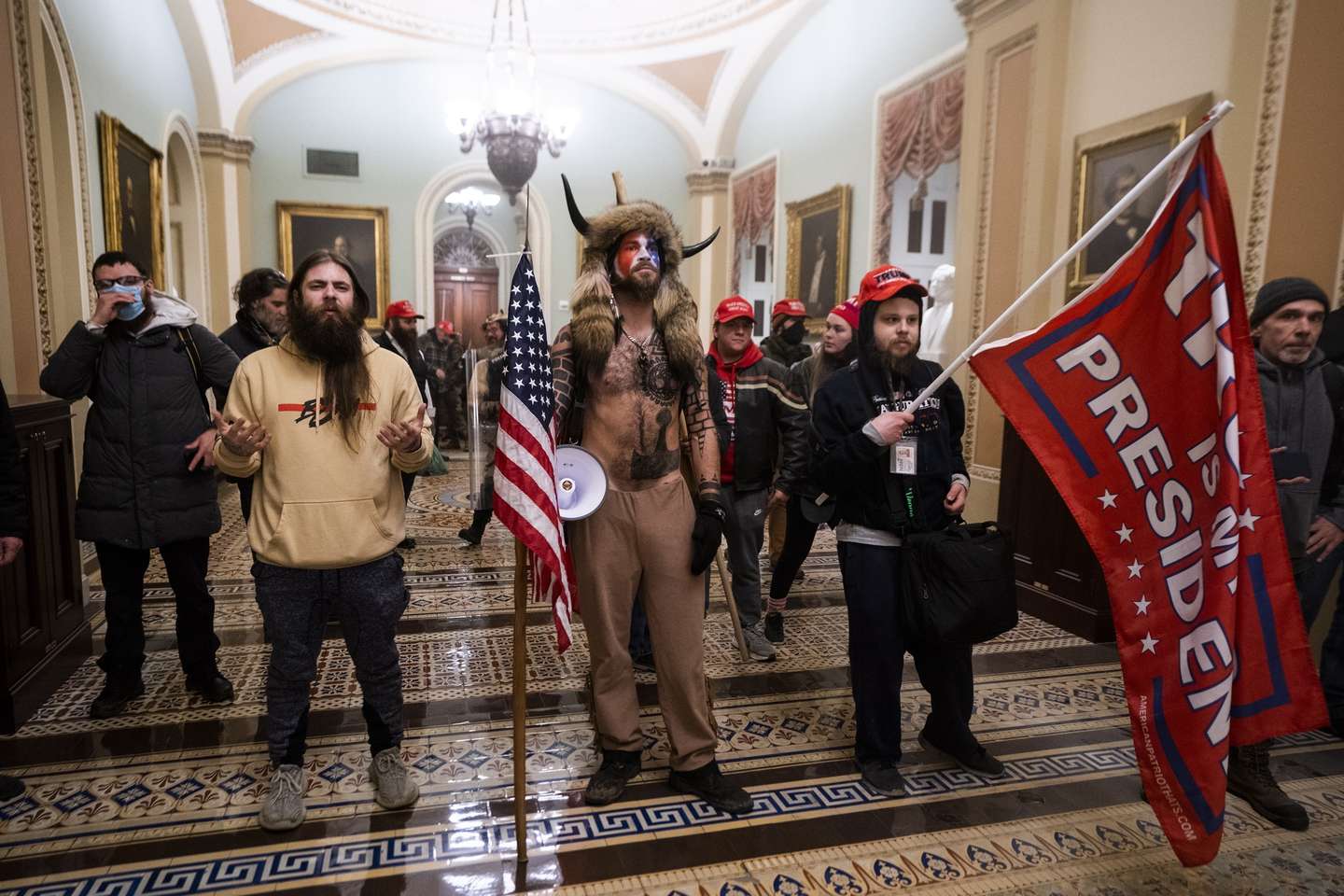 epa09664285 (14/24) (FILE) - Supporters of US President Trump stand by the door to the Senate chambers after they breached the US Capitol security in Washington, DC, USA, 06 January 2021 (reissued 03 January 2021). Following the November 2020 US presidential election, a tone set by supporters of defeated US President Donald Trump escalated further. Trump, who was refusing to concede the victory of Joe Biden, claiming voter fraud and rigged elections, told supporters and white nationalist extreme-right group Proud Boys to respectively 'Stop the Steal' and to 'stand back and stand by'. His social media accounts were suspended and the alt-right platform Parler gained in user numbers. On 06 January 2021, incumbent US vice president Pence was due to certify the Electoral College votes before Congress, the last step in the process before President-elect Biden was to be sworn in. In the morning, pro-Trump protesters had gathered for the so-called Save America March. Soon after Trump finished his speech at the Ellipse, the crowd marched to the Capitol. The attack had begun. Rioters broke into the Capitol building where the joint Congress session was being held. Lawmakers barricaded themselves inside the chambers and donned tear gas masks while rioters vandalized the building, some even occupying offices such as House Speaker Pelosi's. Eventually in the evening the building was cleared from insurrectionists, and the Congress chambers reconvened their session, confirming Joe Biden as the winner of the 2020 US presidential election. In the aftermath, more than 600 people were charged with federal crimes in connection to the insurgency, and close Trump aides such as Steve Bannon, Mark Meadows and Roger Stone were subpoenaed by the House select committee investigating the attack. Trump himself was acquitted by the Senate in his second impeachment trial, this time for "inciting an insurrection". EPA/JIM LO SCALZO ATTENTION: This Image is part of a PHOTO SET *** Loc