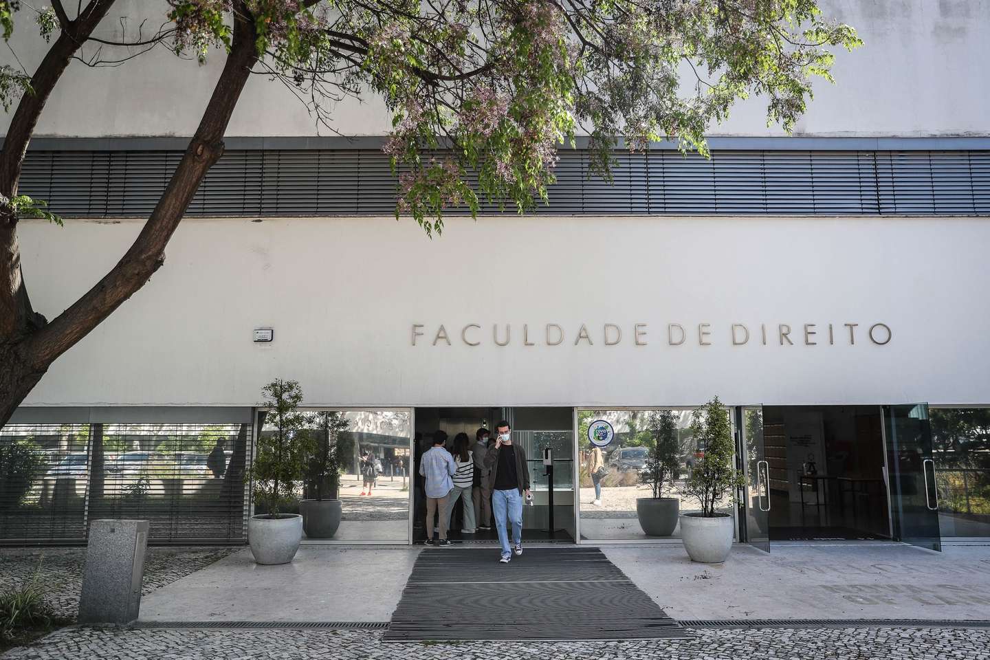 Alunos na entrada da Faculdade de Direito da Universidade de Lisboa, no dia em que se assinala o regresso às aulas no âmbito das novas medidas de desconfinamento relacionadas com a pandemia da covid-19, no Campus de Campolide, em Lisboa, 19 de abril de 2021. Portugal inicia hoje a terceira fase do desconfinamento com a reabertura de mais escolas, lojas, restaurantes e cafés, um levantamento de restrições que não é acompanhado nos 10 concelhos onde a incidência da covid-19 é maior. MÁRIO CRUZ/LUSA