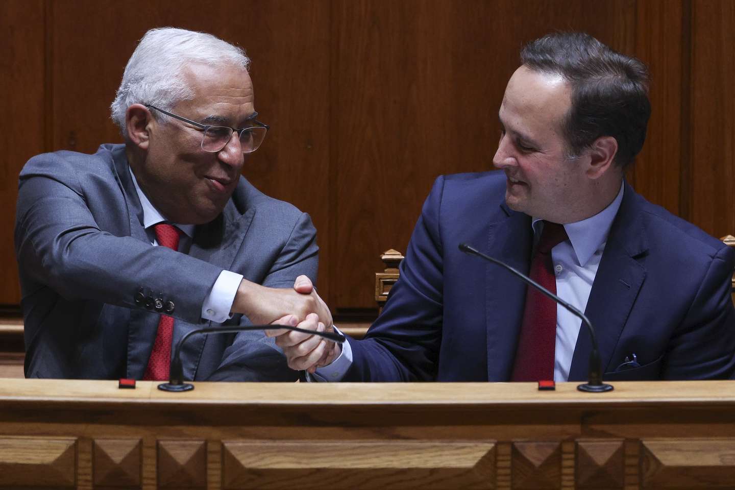 O primeiro ministro, António Costa (E) cumprimenta o ministro das Finanças, Fernando Medina (D) após a aprovação do Orçamento do Estado para 2023 na Assembleia da República em Lisboa, 25 de novembro de 2022. TIAGO PETINGA/LUSA