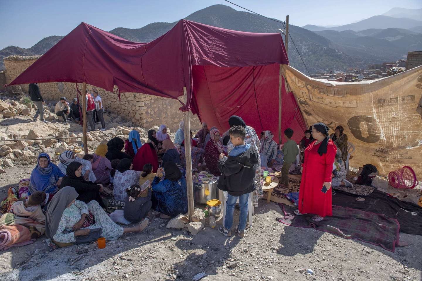 epa10850157 A group of women and children takes shelter under a makeshift tent following an earthquake in Marrakesh, Morocco, 09 September 2023. A powerful earthquake that hit central Morocco late 08 September, killed at least 820 people and injured 672 others, according to a provisional report from the country's Interior Ministry. The earthquake, measuring magnitude 6.8 according to the USGS, damaged buildings from villages and towns in the Atlas Mountains to Marrakesh.  EPA/JALAL MORCHIDI