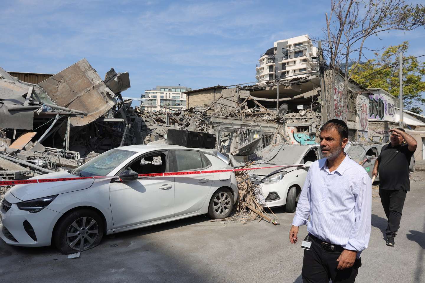 epaselect epa10906895 Residents view destroyed vehicles and structures in Tel Aviv, Israel, 08 October 2023, following overnight Hamas rocket attacks. Rocket barrages were launched from the Gaza Strip as of early 07 October in a surprise attack claimed by the Islamist movement Hamas. More than 300 Israelis were killed and over 1,000 left injured in the attacks, the Israeli foreign ministry said.  EPA/ABIR SULTAN