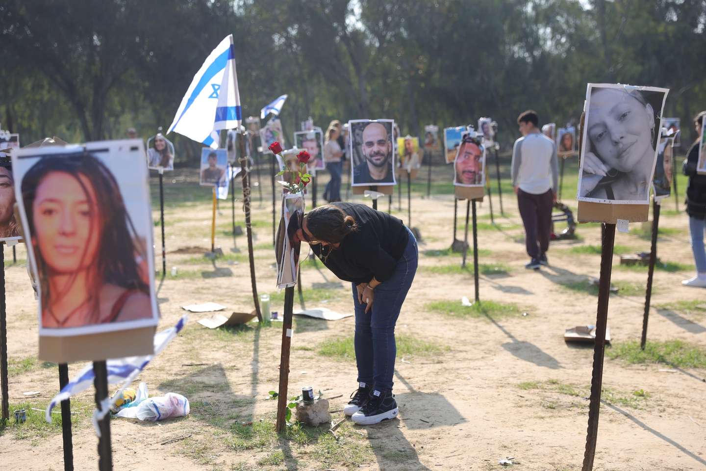 epa11035775 A relative kisses a picture of a victim of the Nova music festival massacre near Reeim, close to the Gaza border in southern Israel, 18 December 2023. A total of 364 people were killed at the Nova music festival as Hamas militants launched an attack against Israel from the Gaza Strip on 07 October.  EPA/ABIR SULTAN