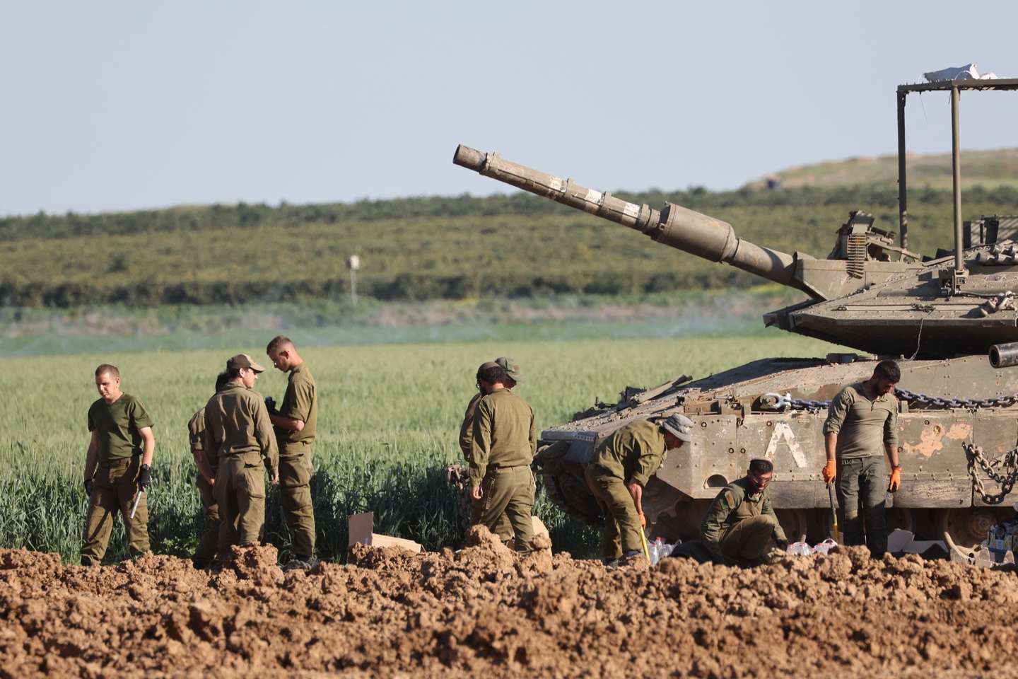 epa11211358 Israeli soldiers stand next to a tank near the border fence with the Gaza Strip, as seen from the Israeli side in southern Israel, 10 March 2024. More than 31,000 Palestinians and over 1,300 Israelis have been killed, according to the Palestinian Health Ministry and the Israel Defense Forces (IDF), since Hamas militants launched an attack against Israel from the Gaza Strip on 07 October 2023, and the Israeli operations in Gaza and the West Bank which followed it.  EPA/ABIR SULTAN