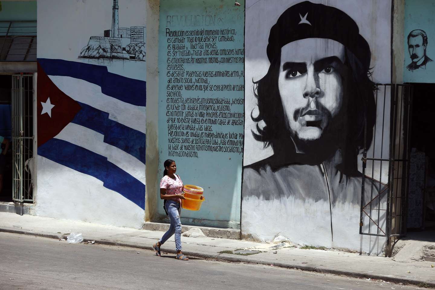 epa11302962 A woman walks in front of a mural with the image of Argentine revolutionary Ernesto Che Guevara in the streets of Havana, Cuba, 26 April 2024.  EPA/Ernesto Mastrascusa