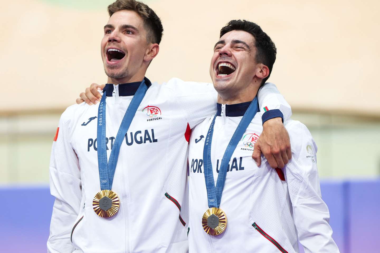 Os ciclistas Iúri Leitão (D) e Rui Oliveira, cantam o Hino Nacional após receberem as medalhas de ouro da conquista em madison em Paris2024, o sexto título olímpico do desporto português, depois dos cinco no atletismo, no 32.º pódio luso de sempre, Paris, França, 10 de agosto de 2024. Depois da medalha de prata de Iúri Leitão no omnium, a dupla lusa somou 55 pontos, nas 200 voltas à pista do Velódromo Saint-Quentin-en-Yvelines, mais oito do que a Itália, com Simone Consonni e Elia Viviani, segunda classificada, enquanto a Dinamarca, com Niklas Larsen e Michael Moerkoev, terminou no terceiro posto, com 41. JOSÉ SENA GOULÃO/LUSA